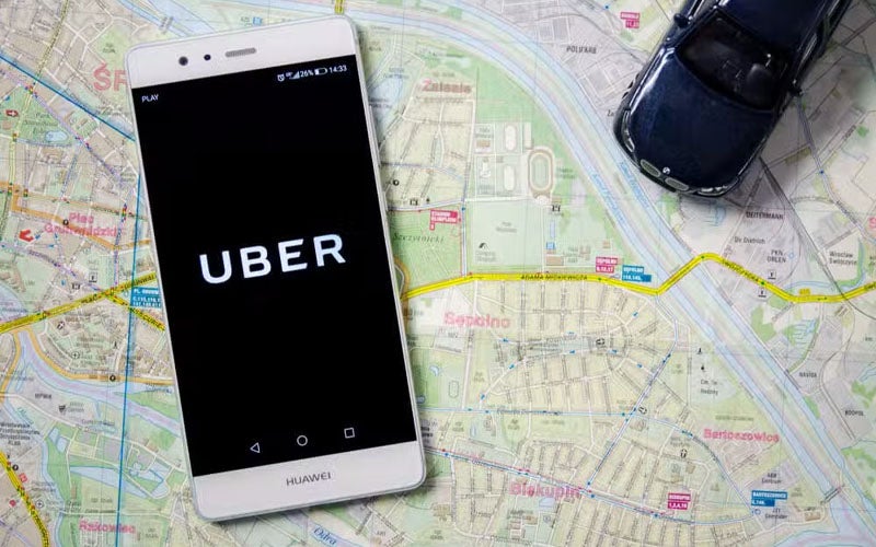 Cell phone with uber app open sitting on a map